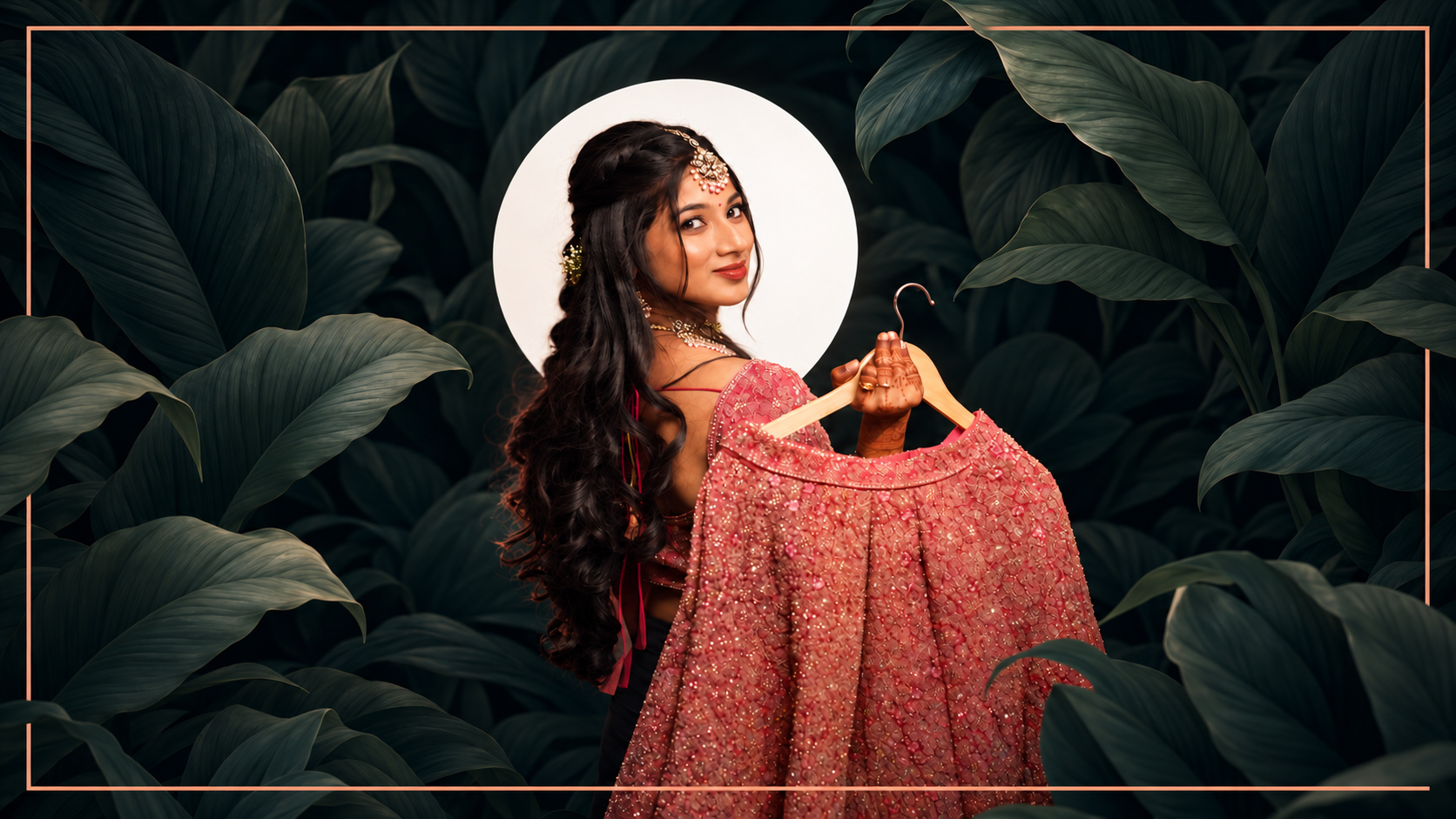 Bride in a red sari against a leaf backdrop