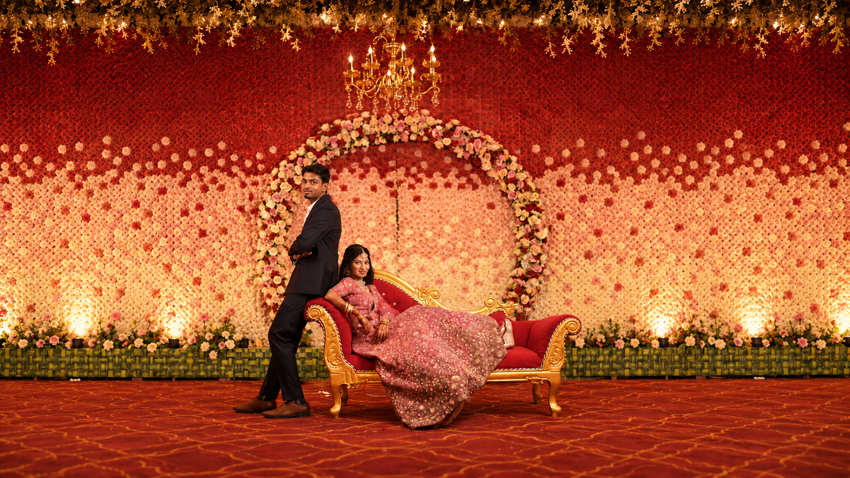 Couple seated together against a floral wedding backdrop